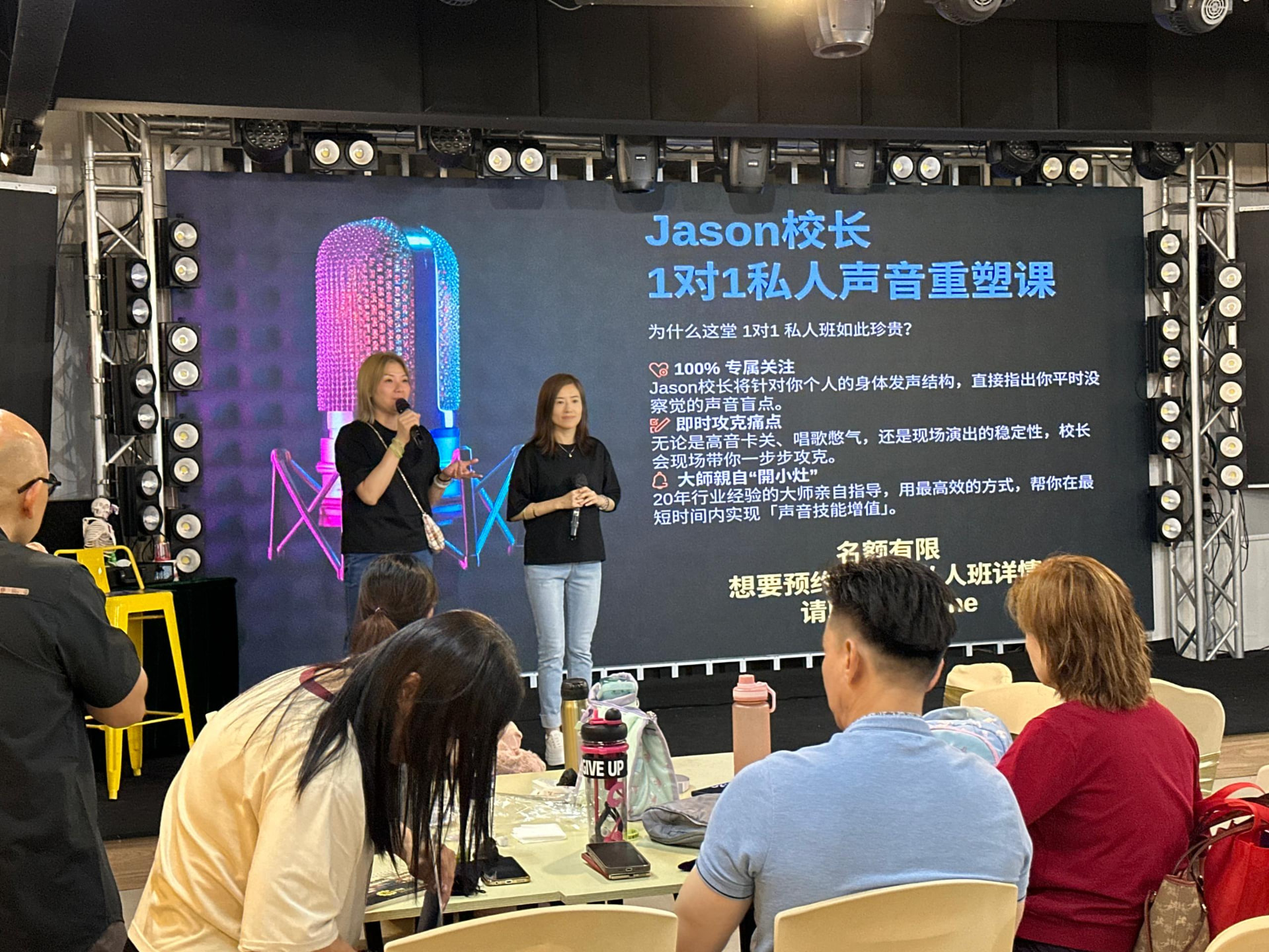Vocal coaching masterclass with speakers presenting course details on the LED screen at Dreamlive Event Space Puchong