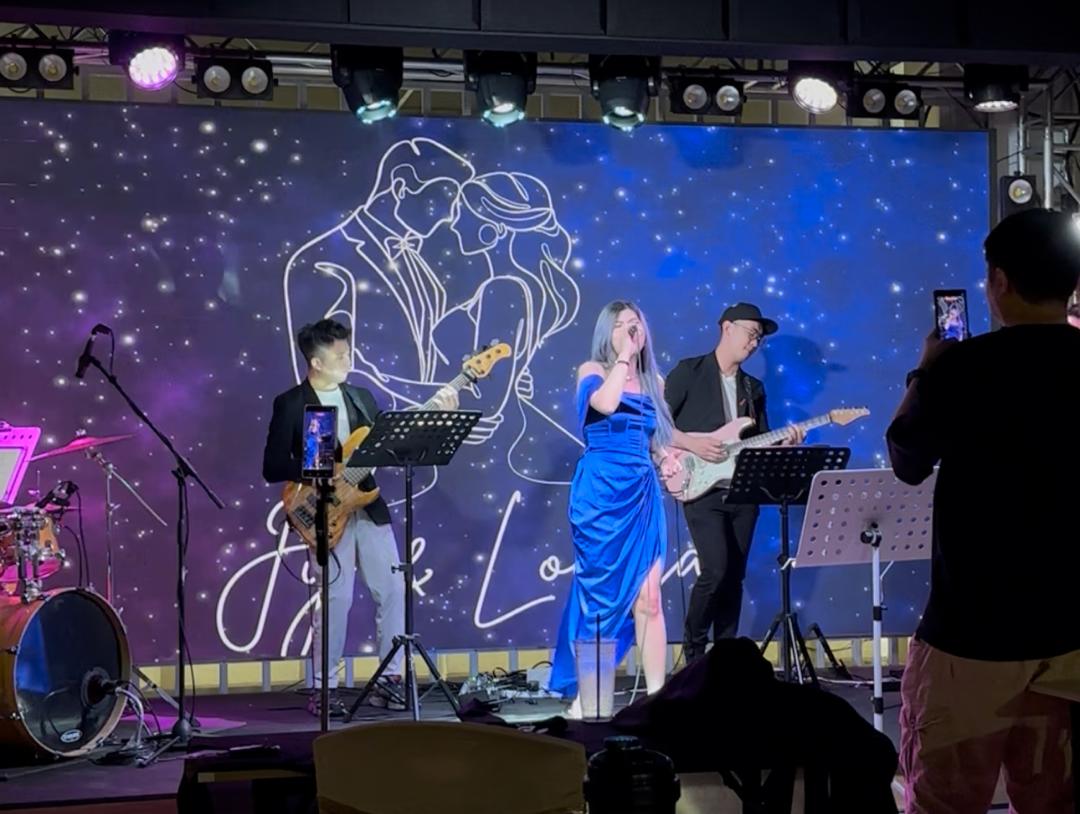 Live band with vocalist and guitarists performing on stage under event lighting at Dreamlive Event Space Puchong
