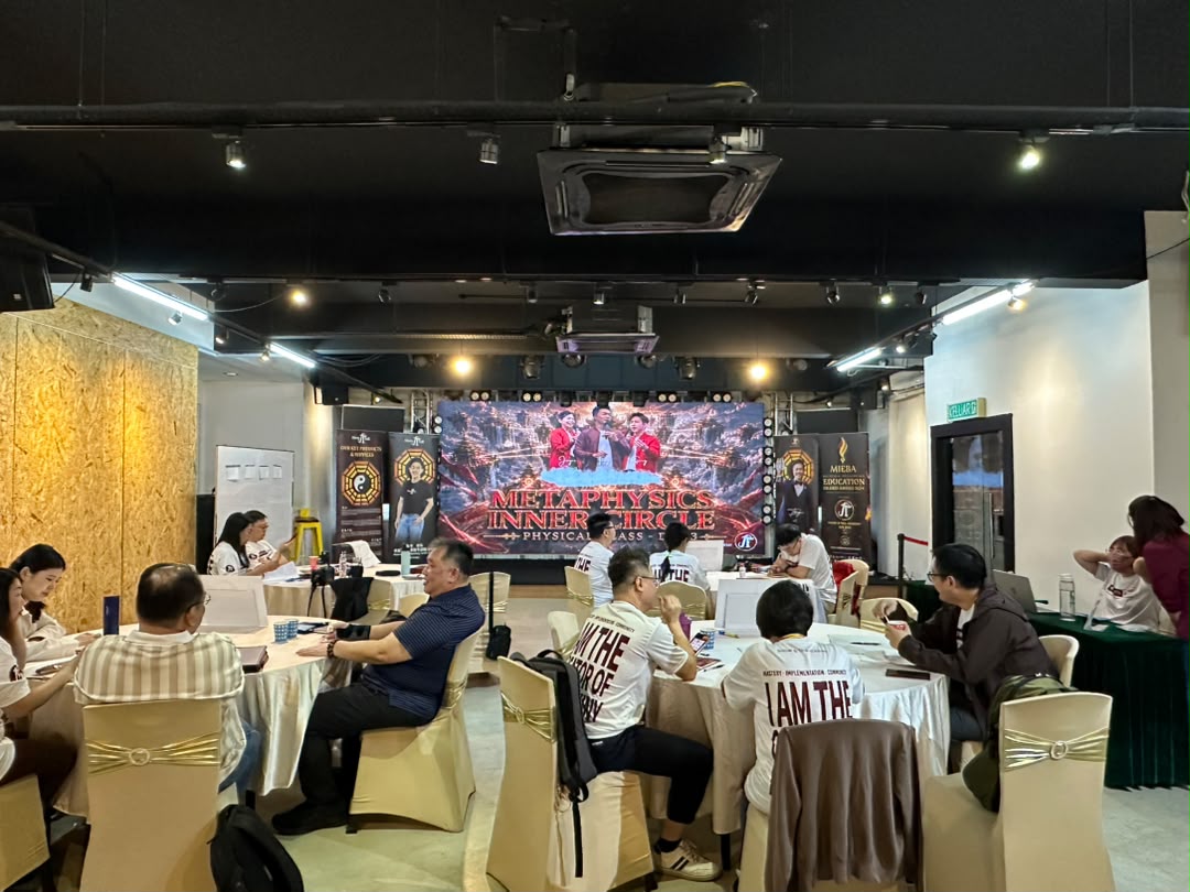 Small-group workshop with participants at round tables facing the LED screen at Dreamlive Event Space Puchong